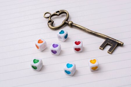 Key and colorful cubes with a heart placed on paperの写真素材