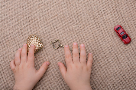 Heart shaped gold color metal object in hand