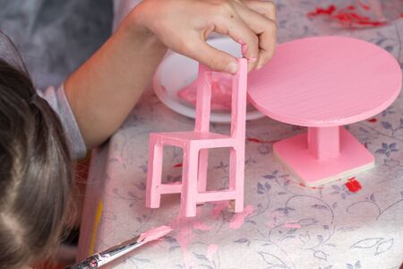 Young children decorating handmade wooden chairの写真素材
