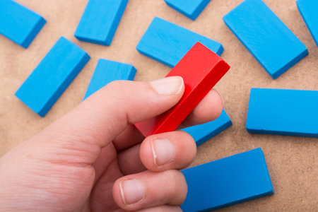Hand holding one of the wooden blocks of various colorsの写真素材