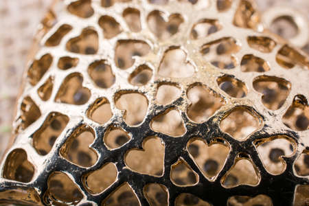 Heart shaped gold color metal object on canvasの写真素材