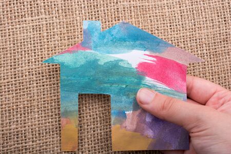 Hand holding a aper house on a canvas backgroundの写真素材