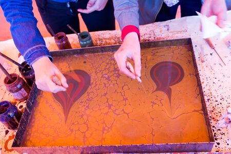 Hand drawing with stick stained inks on water surfaceの写真素材