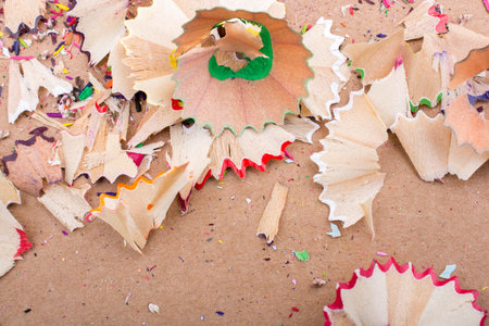 Colorful pencil shavings on a brown background