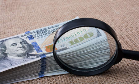Magnifying glass  over the banknote bundle of US dollarの写真素材