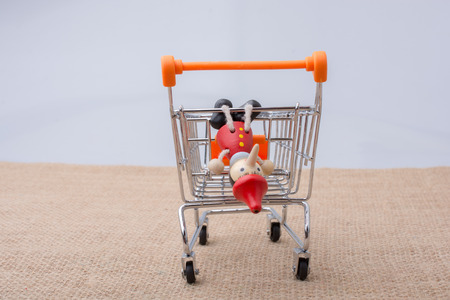 Pinocchio sitting on shopping trolley on a canvas backgroundの写真素材