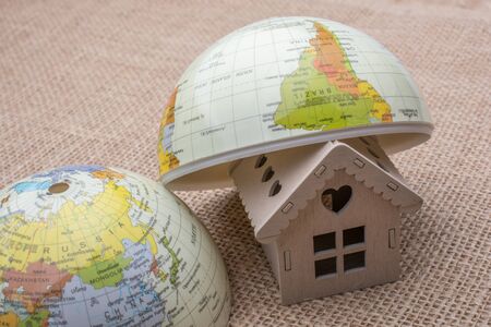 Model house and a globe on a linen canvasの写真素材