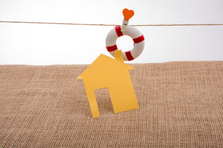 Model house and a life preserver with a heart on a stringの写真素材