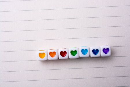 Colorful cubes with a heart placed on paperの写真素材