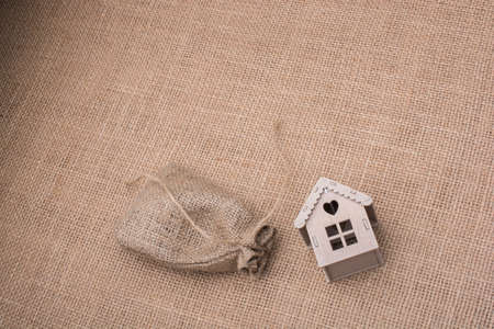 Model house beside a sack on a canvas backgroundの写真素材