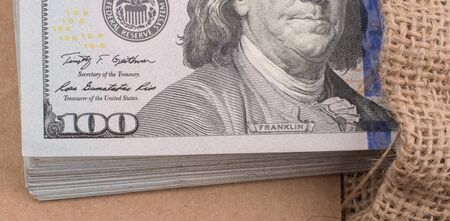 Banknote bundle of US dollarin a sack on a canvasの写真素材
