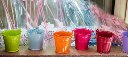Little set of buckets of various colors in a market placeの写真素材