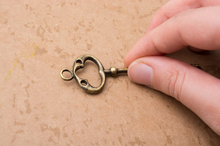 Hand holding a retro styled  golden color   decorative key