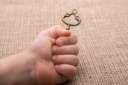 Hand holding a retro styled  golden color   decorative keyの写真素材