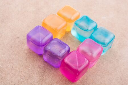 Fake colorful ice cubes on a brown backgroundの写真素材