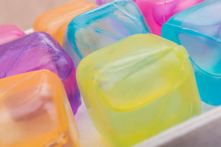 Fake colorful ice cubes on a brown backgroundの写真素材