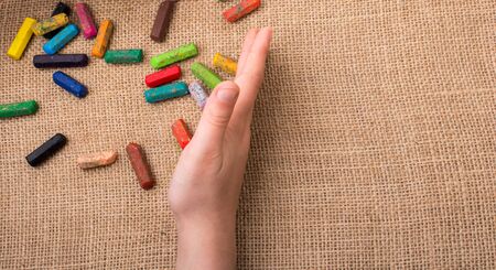 Used  color crayons and a hand holding someの写真素材