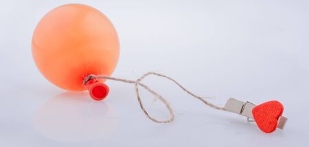 Clothespin with a heart tied to a baloon with a stringの写真素材