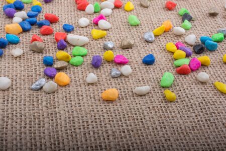 Colorful pebbles spread on a canvas backgroundの写真素材