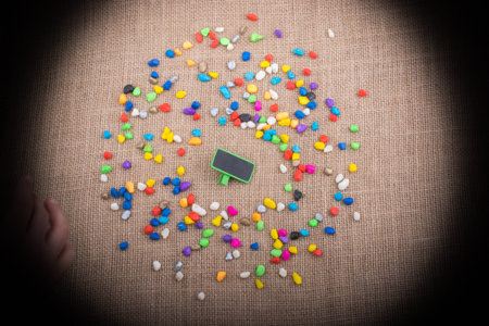 Little noticeboard amid Colorful pebbles spread on canvas