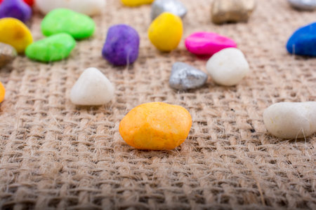 Colorful pebbles spread on a canvas background