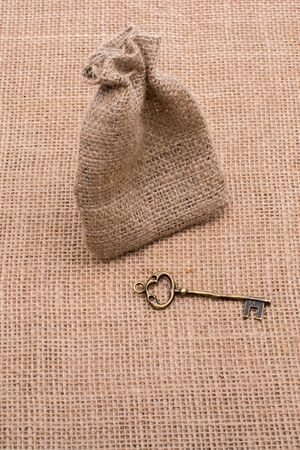 Retro styled golden color key beside a sackの写真素材