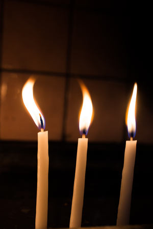 Burning candles with candle light in the darkの写真素材
