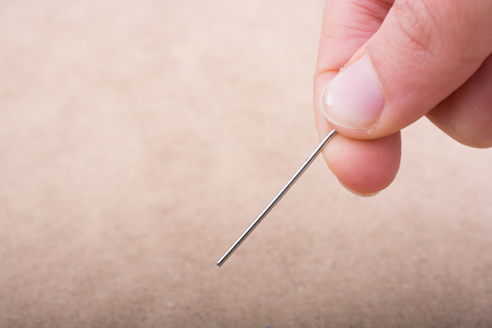 Hand holding an  syringe over a white backgroundの写真素材