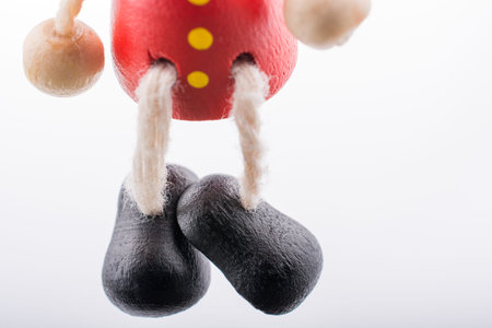 Wooden Pinocchio doll  with its legs in viewの写真素材