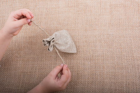 Hand holding an empty little sack made of linenの写真素材
