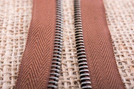 Parts of the brown color zipper on linen canvas backgroundの写真素材