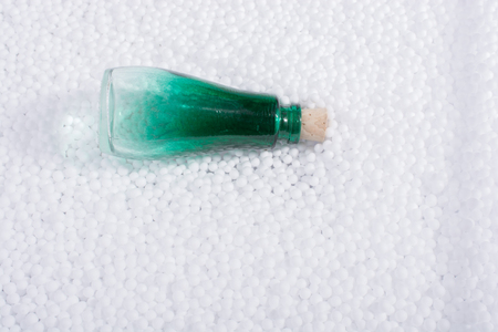 Empty bottle on little  white polystyrene foam ballsの写真素材