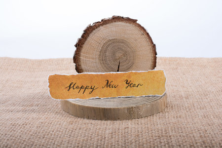 Happy new year written torn  paper  on a piece of logの写真素材