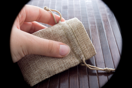Hand holding an empty little sack made of linenの写真素材