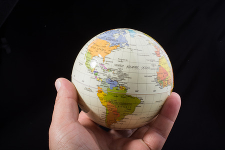 Hand holding a globe  with map on itの写真素材