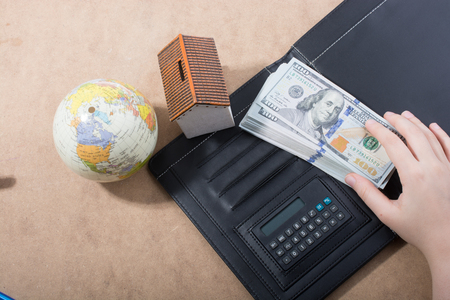Hand holding American dollar banknotes on a wooden backgroundの写真素材