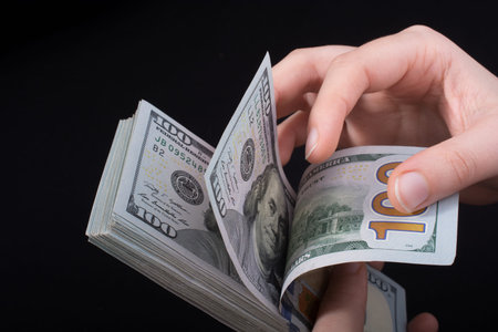 Hand holding American dollar  banknotes isolated on white background