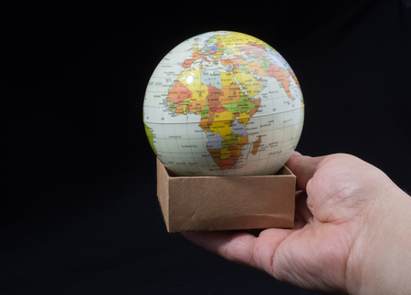 Hand holding a globe  with map on itの写真素材