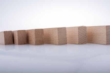 Wooden Domino Blocks in a line on a white backgroundの写真素材