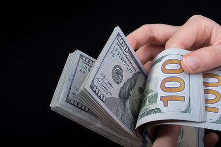 Hand holding American dollar  banknotes isolated on white backgroundの写真素材