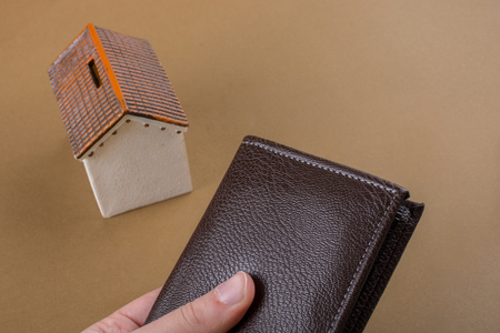 Little model house  beside a wallet in handの写真素材