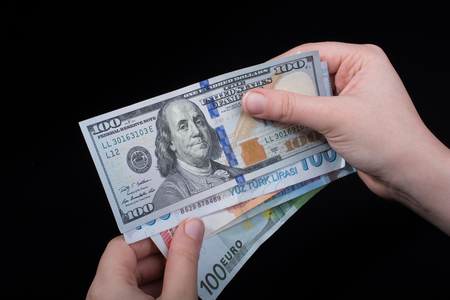 Hand holding American dollar  banknotes isolated on black backgroundの写真素材