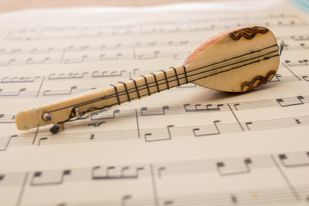 Model of Turkish musical instrument saz  on paper with musical notesの写真素材