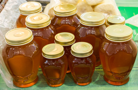 Glass jar of full of fresh honey with lidの写真素材