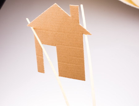 Little house shape cut out of paper on a canvas backgroundの写真素材