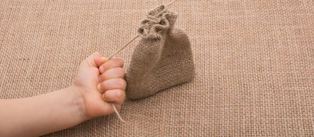 Hand holding an empty little sack made of linenの写真素材