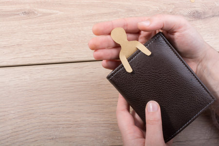 Man shape cut out of paper in wallet in hand