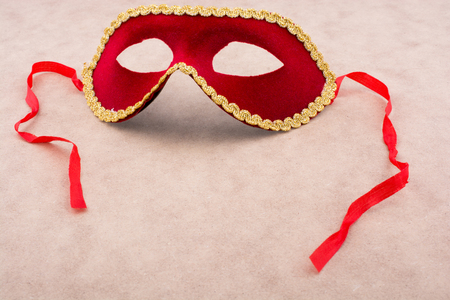 Beautiful festive carnival mask with ribbons on light brown backgroundの写真素材