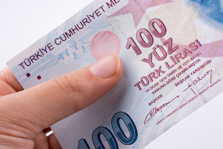 Hand holding 100 Turksh Lira banknotes  on white backgroundの写真素材