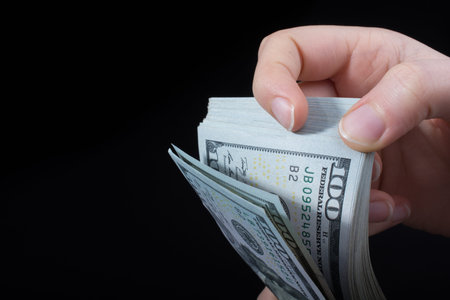 Hand holding American dollar  banknotes isolated on white background